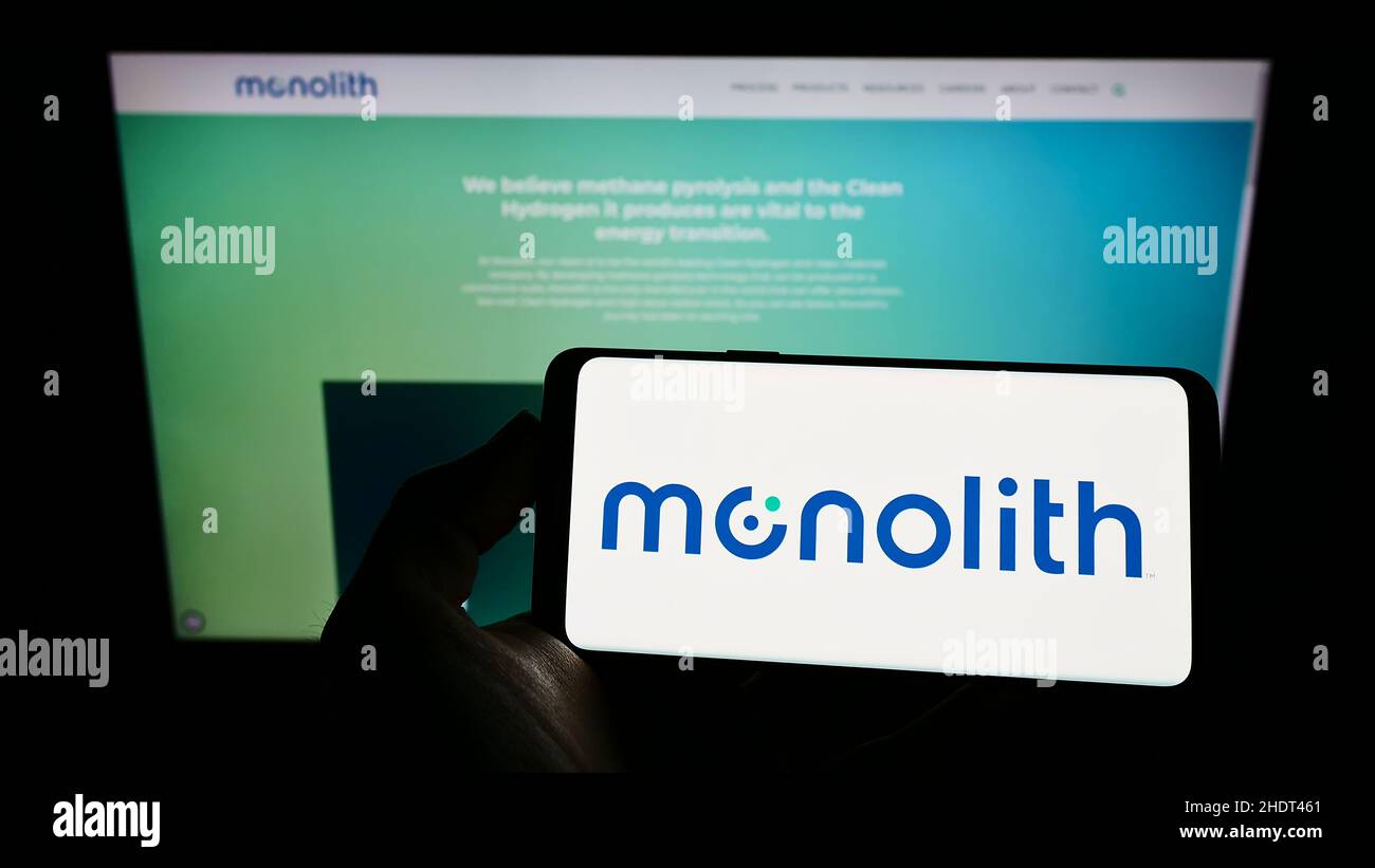 Personne tenant un téléphone portable avec le logo de la société américaine d'hydrogène Monolith Inc. À l'écran devant la page Web d'affaires.Mise au point sur l'affichage du téléphone. Banque D'Images