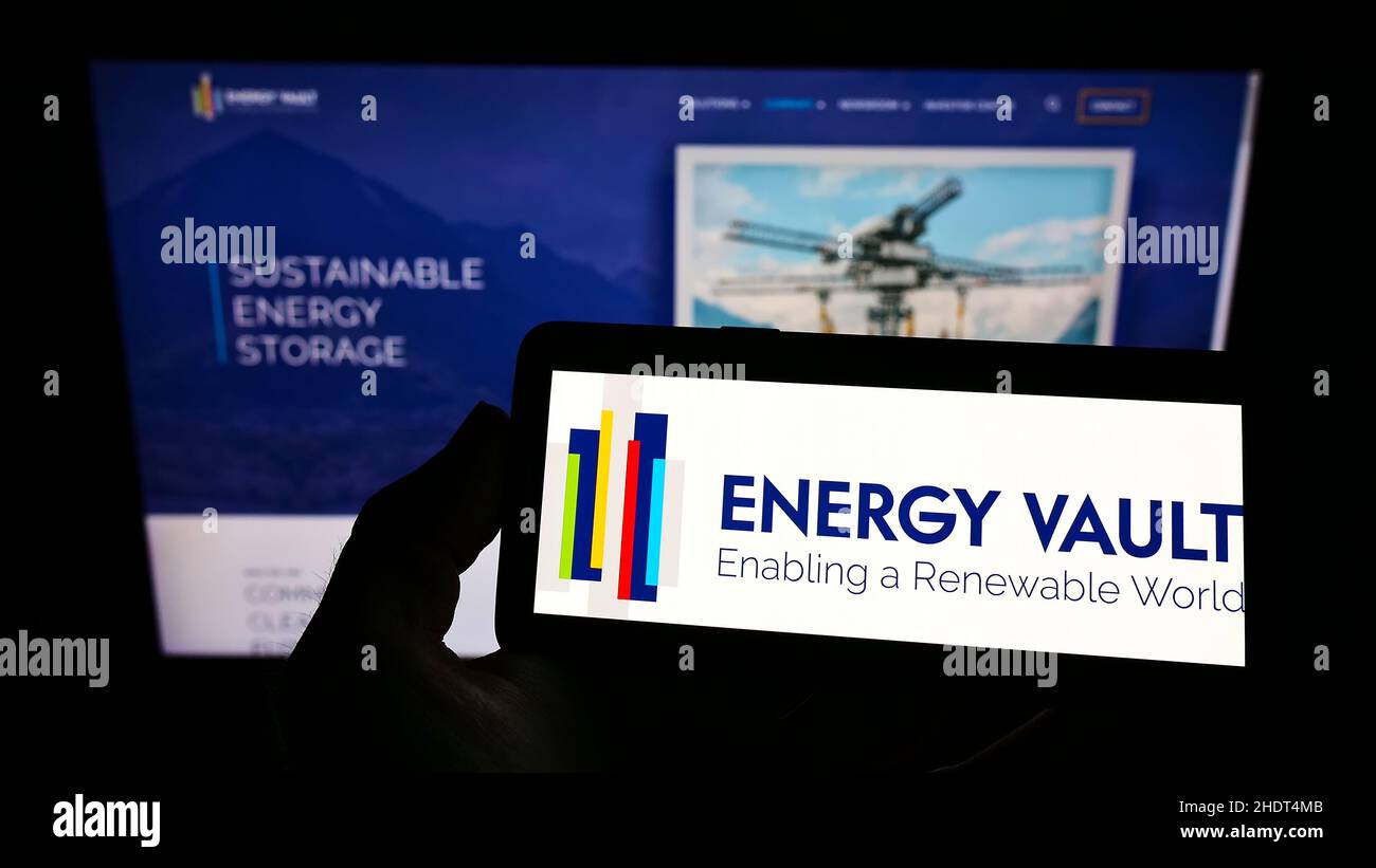 Personne tenant un smartphone avec le logo de la société suisse de stockage d'énergie Energy Vault Inc. À l'écran devant le site Web.Mise au point sur l'affichage du téléphone. Banque D'Images