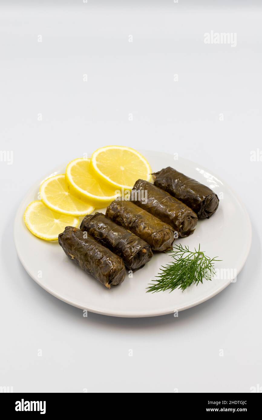 Feuilles de raisin farcies à l'huile d'olive sur fond blanc.Spécialités turques traditionnelles.Délicieux dolma (yabrak sarma).Vue verticale.Clos Banque D'Images