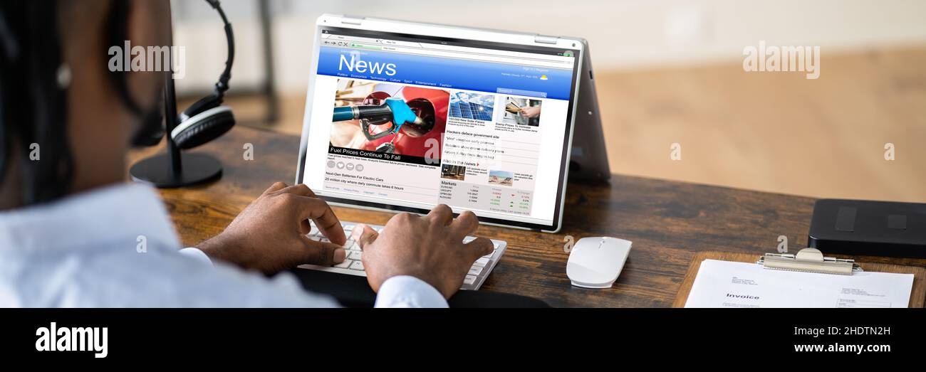 Homme d'affaires consulte les actualités en ligne sur un ordinateur portable à son bureau Banque D'Images