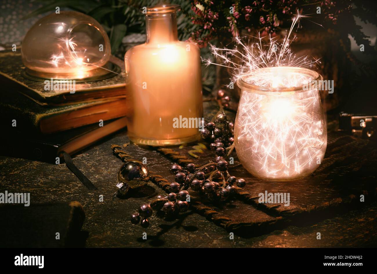 Lumières magiques avec des sparkles et orange phosphorescent dans des pots en verre vintage.Lumières et livres anciens.Plantes d'intérieur et pot de fleur de bruyère.Soirée romantique. Banque D'Images