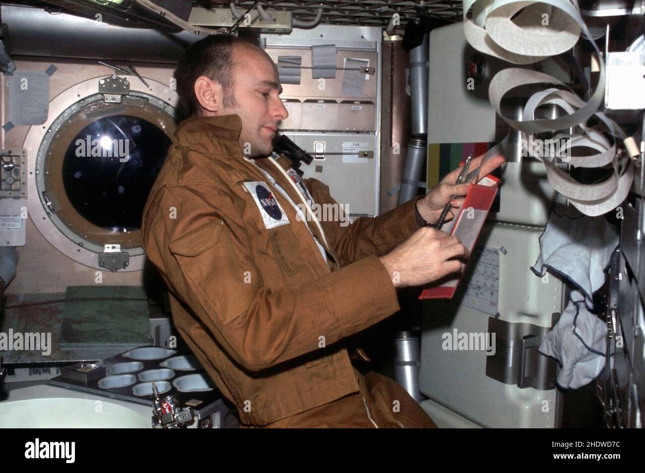 (Juillet-septembre 1973) --- l'astronaute Alan L. Bean, commandant du Skylab 3, lit les données du livre dans sa main droite tout en tenant la bande de téléimprimeur dans sa main gauche, dans la salle de paroisse des quartiers d'équipage de l'atelier orbital de la station spatiale Skylab (OWS).Cette photo a été prise avec un appareil photo Nikon de 35mm tenu par l'un des membres d'équipage de Bean pendant la deuxième mission Skylab de 56,5 jours en orbite terrestre. Banque D'Images