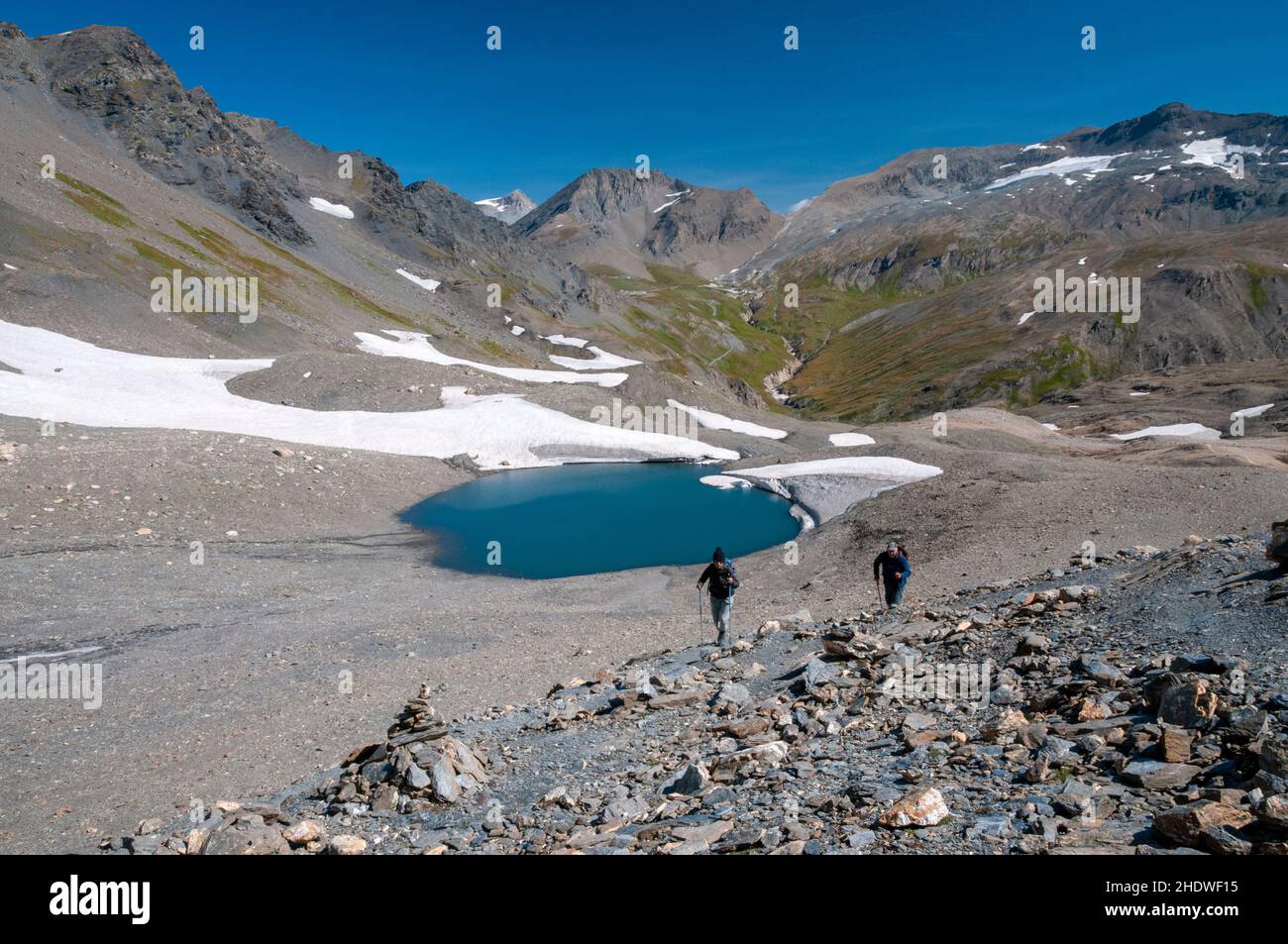 Randonneurs au bord du lac de l'ancien glacier de la Jave avec le sommet du signal de l'Iseran (3237m) et la montagne des pers passent en arrière-plan, massif de la Vanoise, Hau Banque D'Images