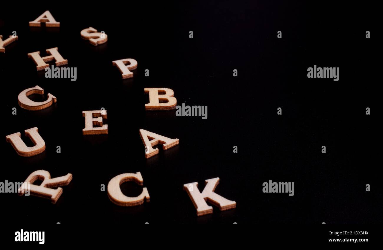 lettres en bois aléatoires isolées sur fond noir Banque D'Images
