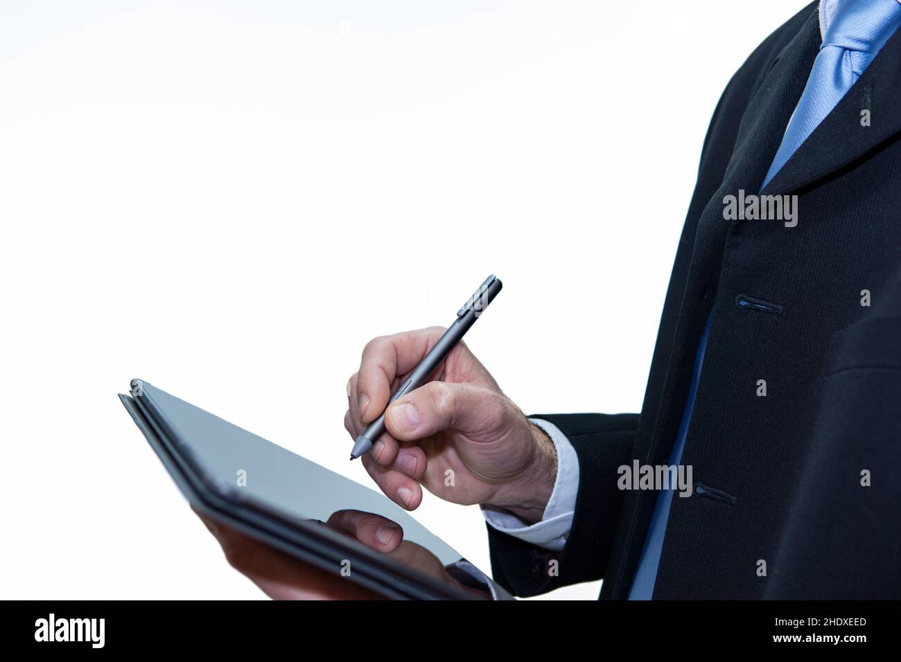 Homme d'affaires méconnu avec une tablette à l'aide d'un stylo numérique, fond blanc Banque D'Images