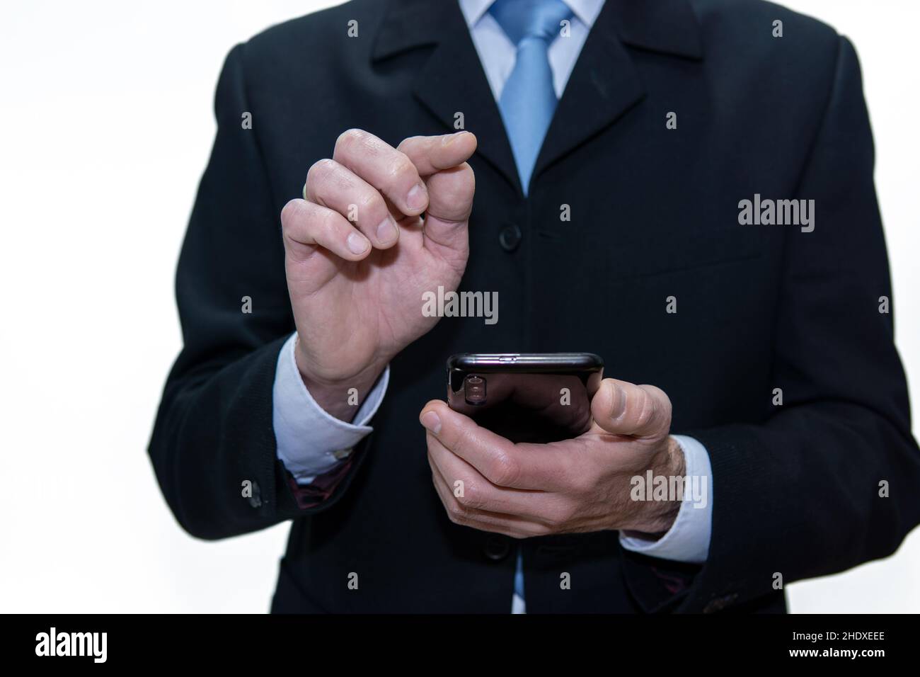Homme d'affaires méconnu utilisant un smartphone, fond blanc Banque D'Images