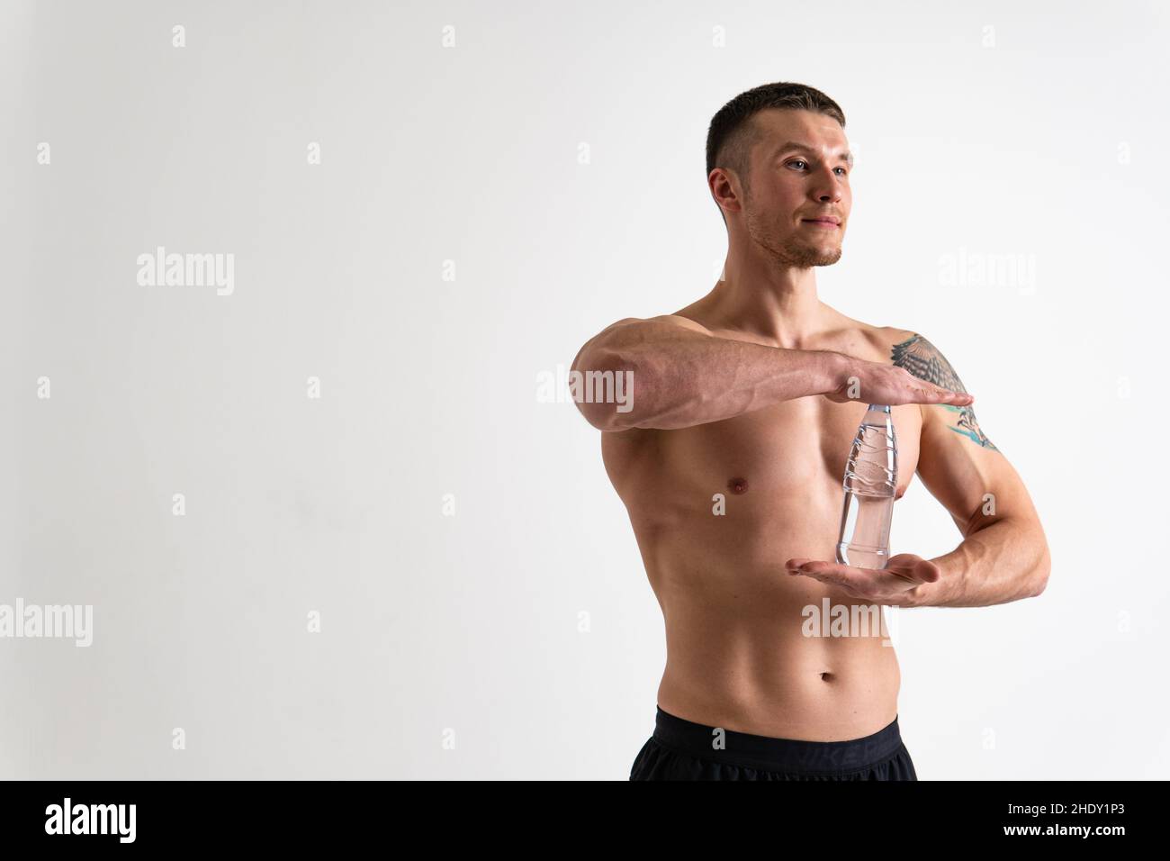 La forme physique de boisson-eau masculine est pompée avec une serviette sur un fond blanc athlète isolé boire sain des muscles de bouteille de gym Bodybuilding pouvoir caucasien o Banque D'Images