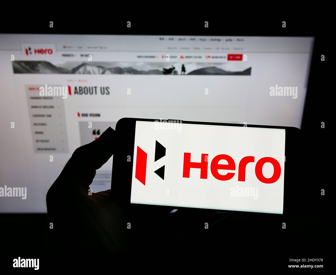 Personne tenant un téléphone mobile avec le logo de la compagnie automobile indienne Hero MotoCorp Limited sur l'écran devant la page Web.Mise au point sur l'affichage du téléphone. Banque D'Images