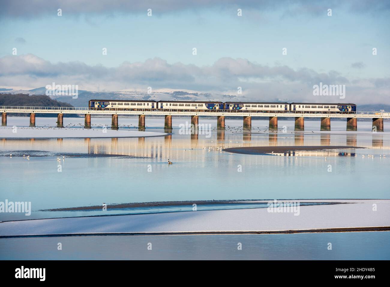 Train ferroviaire du Nord traversant le viaduc d'Arnside dans la neige, Arnside, Milnthorpe, Cumbria, Royaume-Uni Banque D'Images