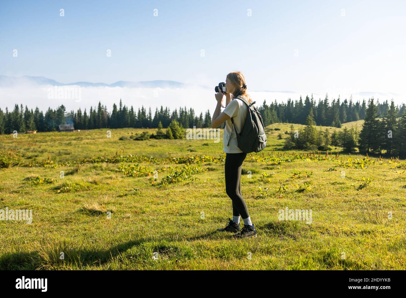 Le photographe prend une photo au sommet de la montagne.Magnifique paysage des Carpates arrière-plan bannière panorama avec collines, nuages et forêt à l'aube Banque D'Images