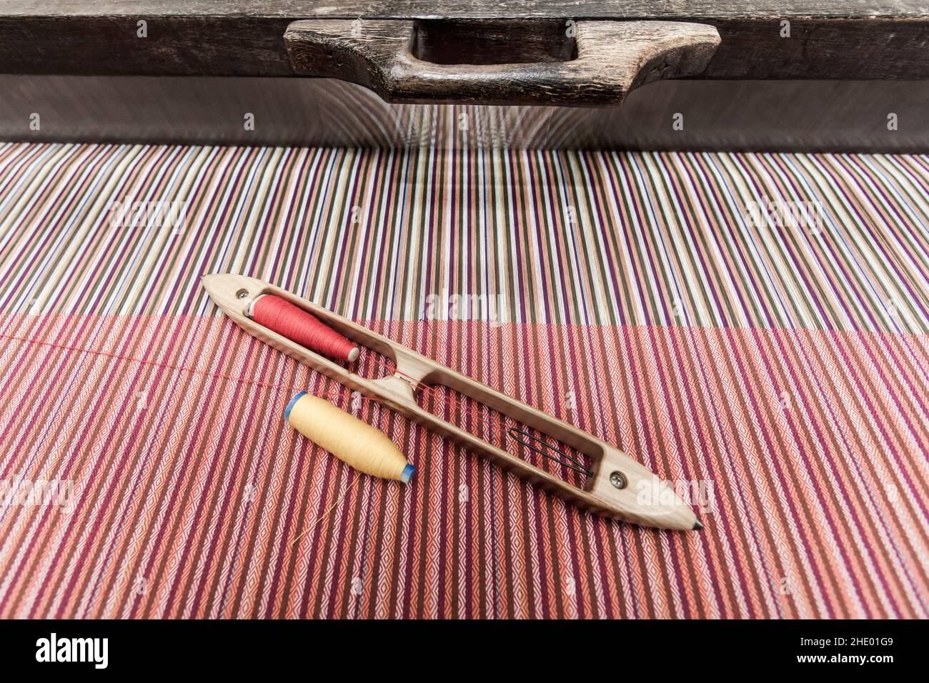 Métier à tisser traditionnel thaïlandais en bois et navette de tissage avec des couleurs fil de couture sur le coton tissé.Gros plan.Vue de dessus. Banque D'Images
