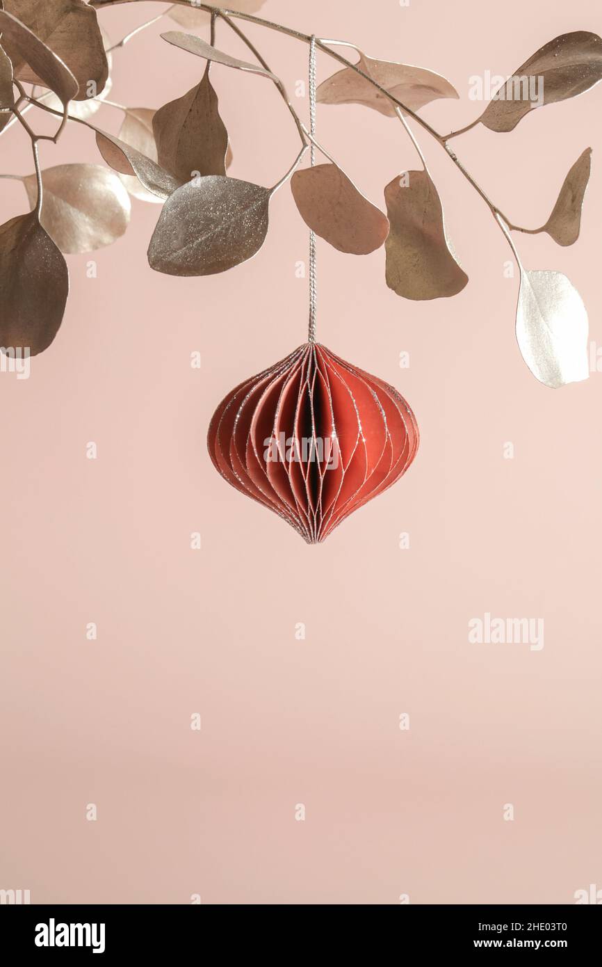 Décoration de Noël en papier nid d'abeille sur branche dorée sur fond beige.Vacances saisonnières, carte de vœux, vacances écologiques. Banque D'Images