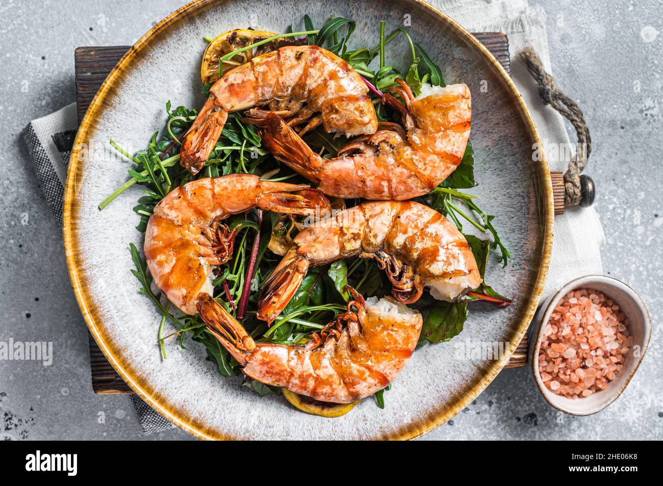 Salade avec crevettes géantes grillées dans un plat.Arrière-plan gris.Vue de dessus Banque D'Images