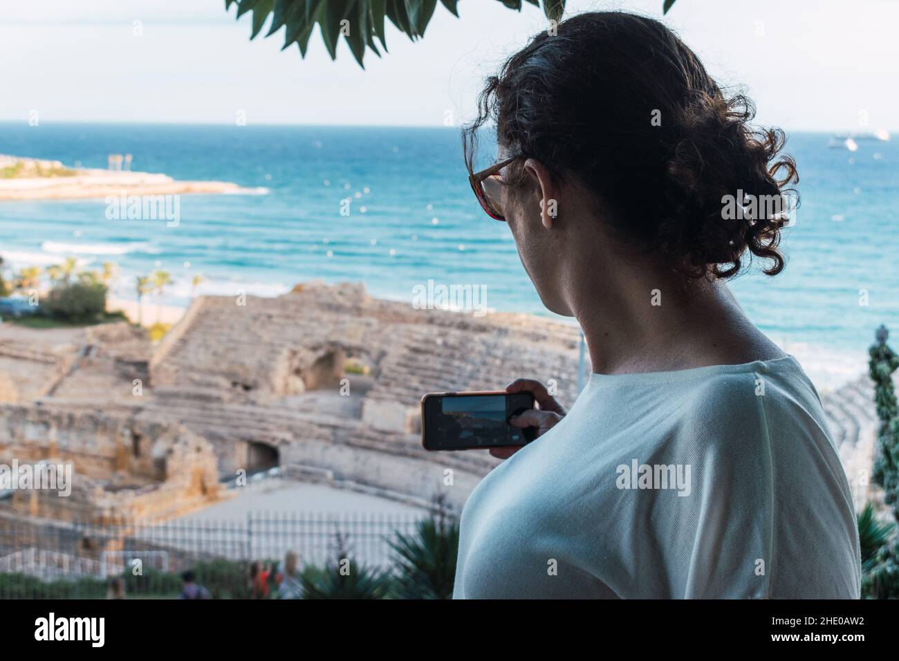 Femme de retour prenant une photo avec le téléphone intelligent à un monument Banque D'Images