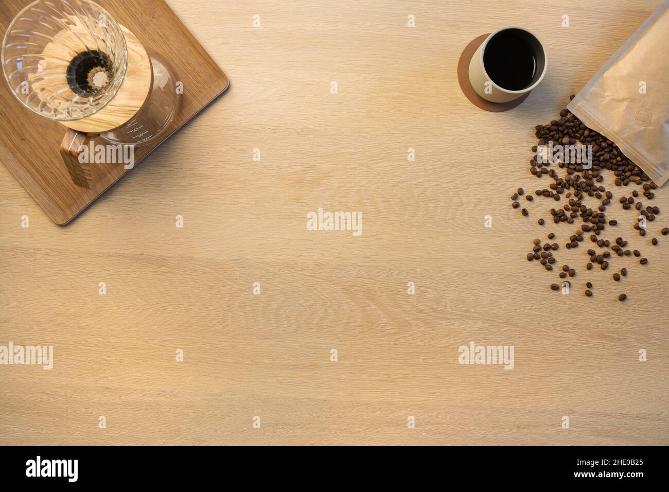 Vue en hauteur des grains de café avec tasse et récipients filtrants sur la table Banque D'Images