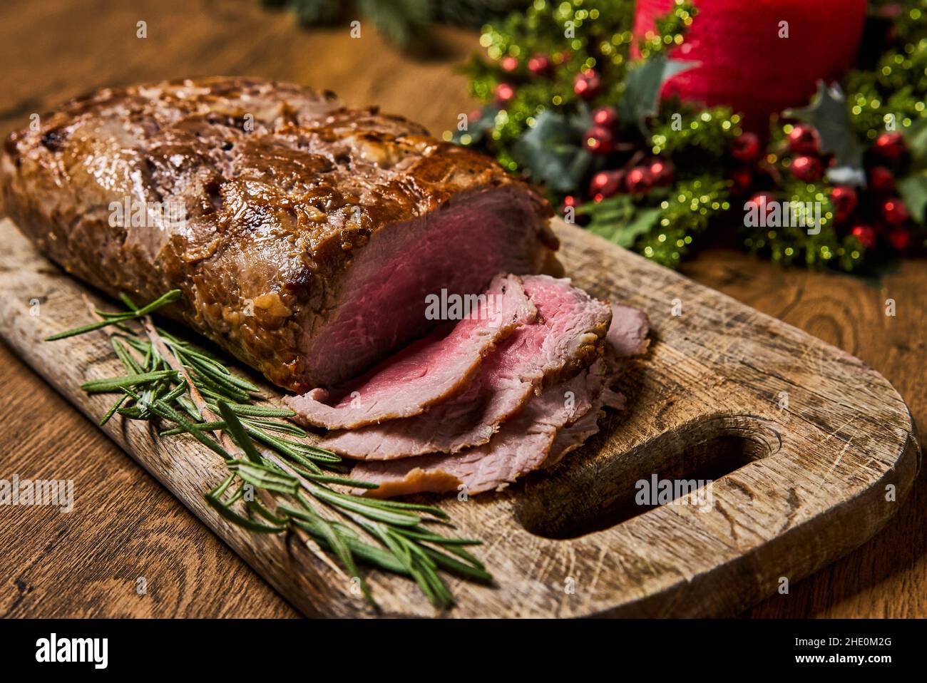 Viande rôtie en tranches, isolée sur fond de bois. Banque D'Images