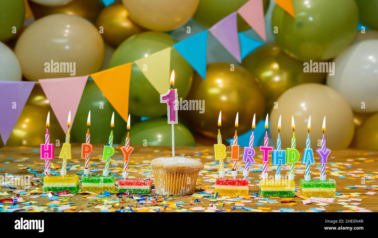 Joyeux anniversaire carte de voeux pour bébé 1 ans, gâteau d'anniversaire avec bougies et décorations d'anniversaire sur fond bleu.Belle carte de vœux. Banque D'Images