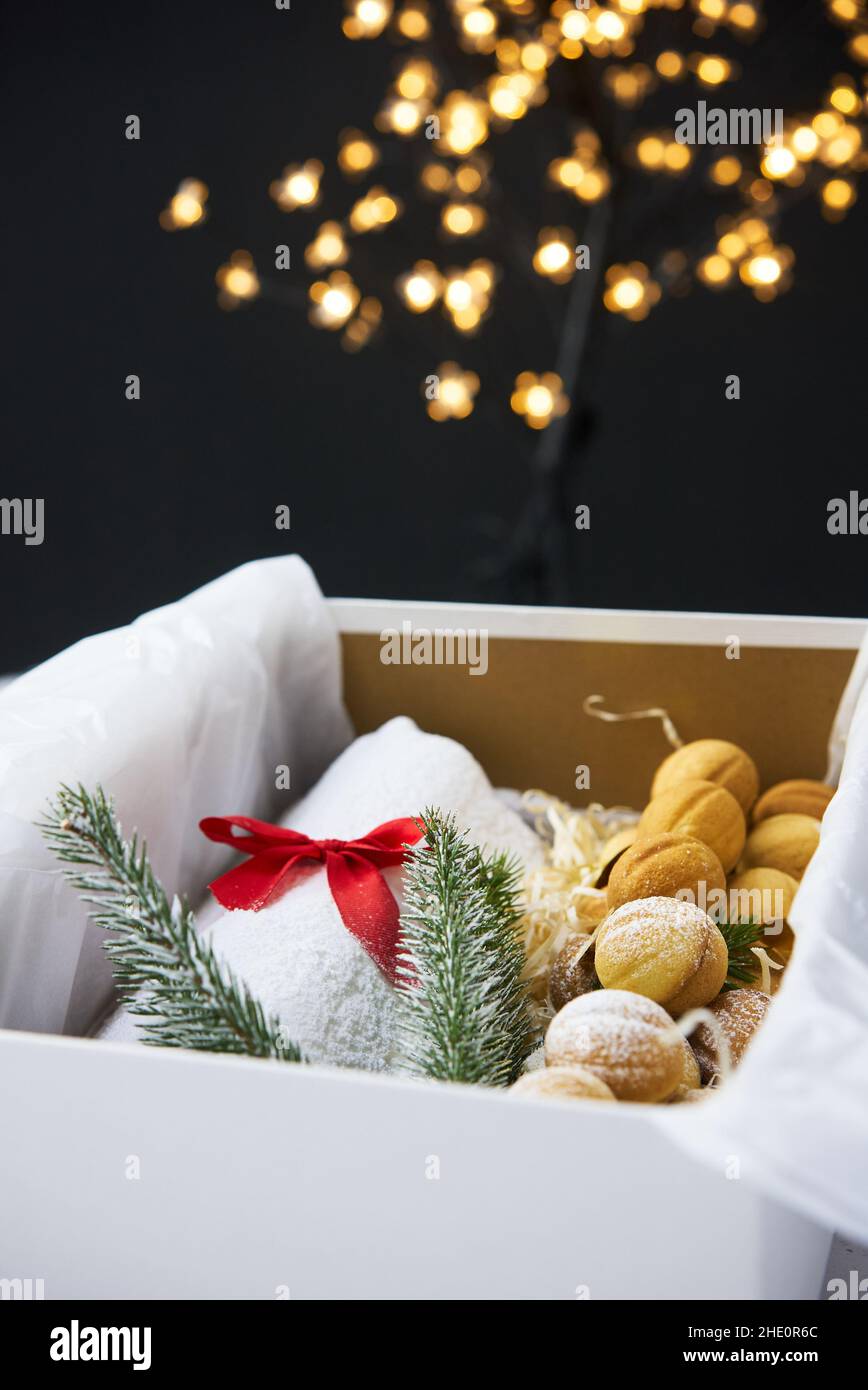 Un stollen de Noël traditionnel fait de fruits secs et de noix arrosées de sucre en poudre sur le fond d'un décor de Noël avec des bougies Banque D'Images