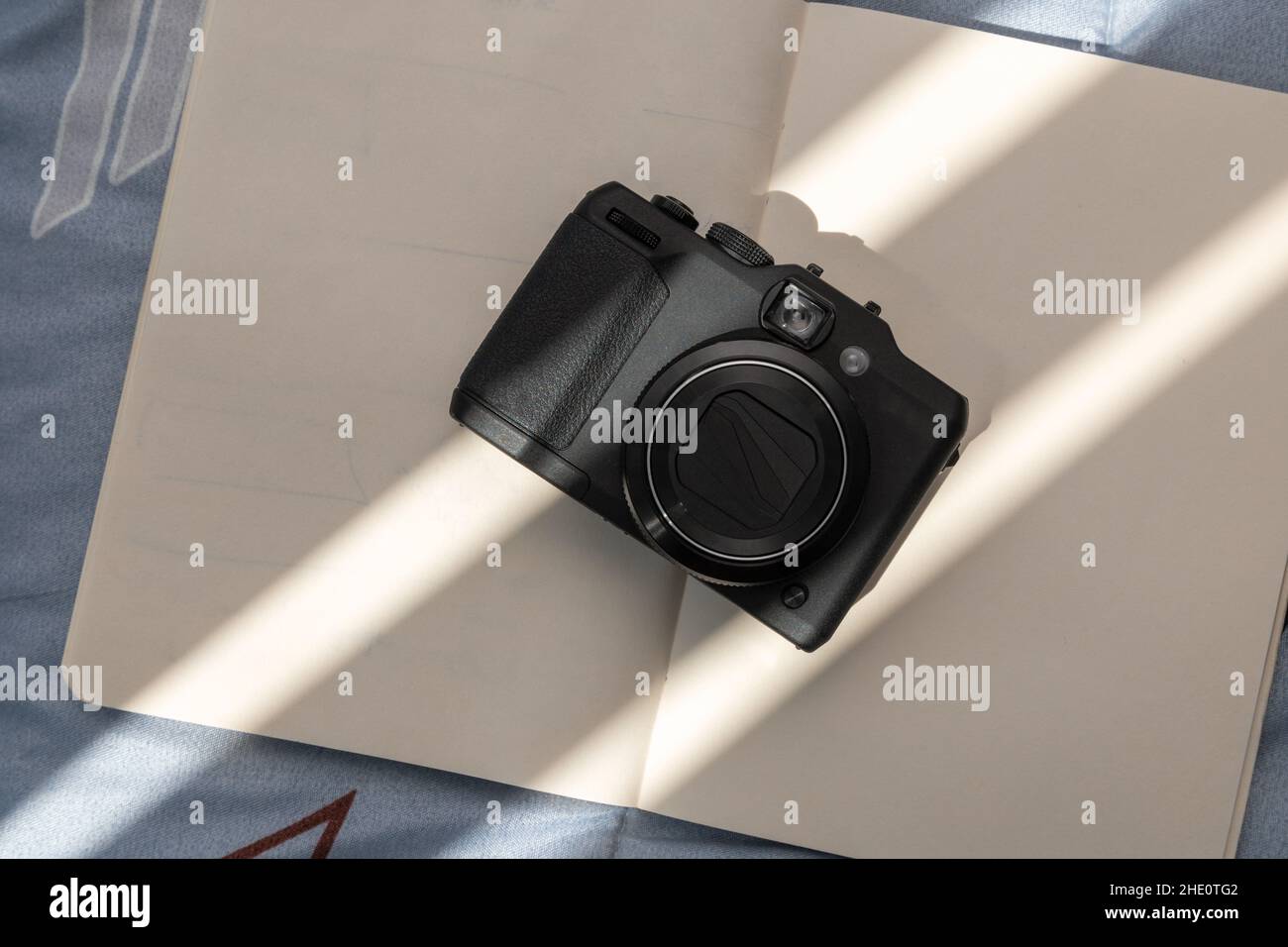 appareil photo moderne sur un ordinateur portable ouvert avec des feuilles vierges, des détails de la technologie et des articles d'art, des passe-temps et des passe-temps de la créativité Banque D'Images