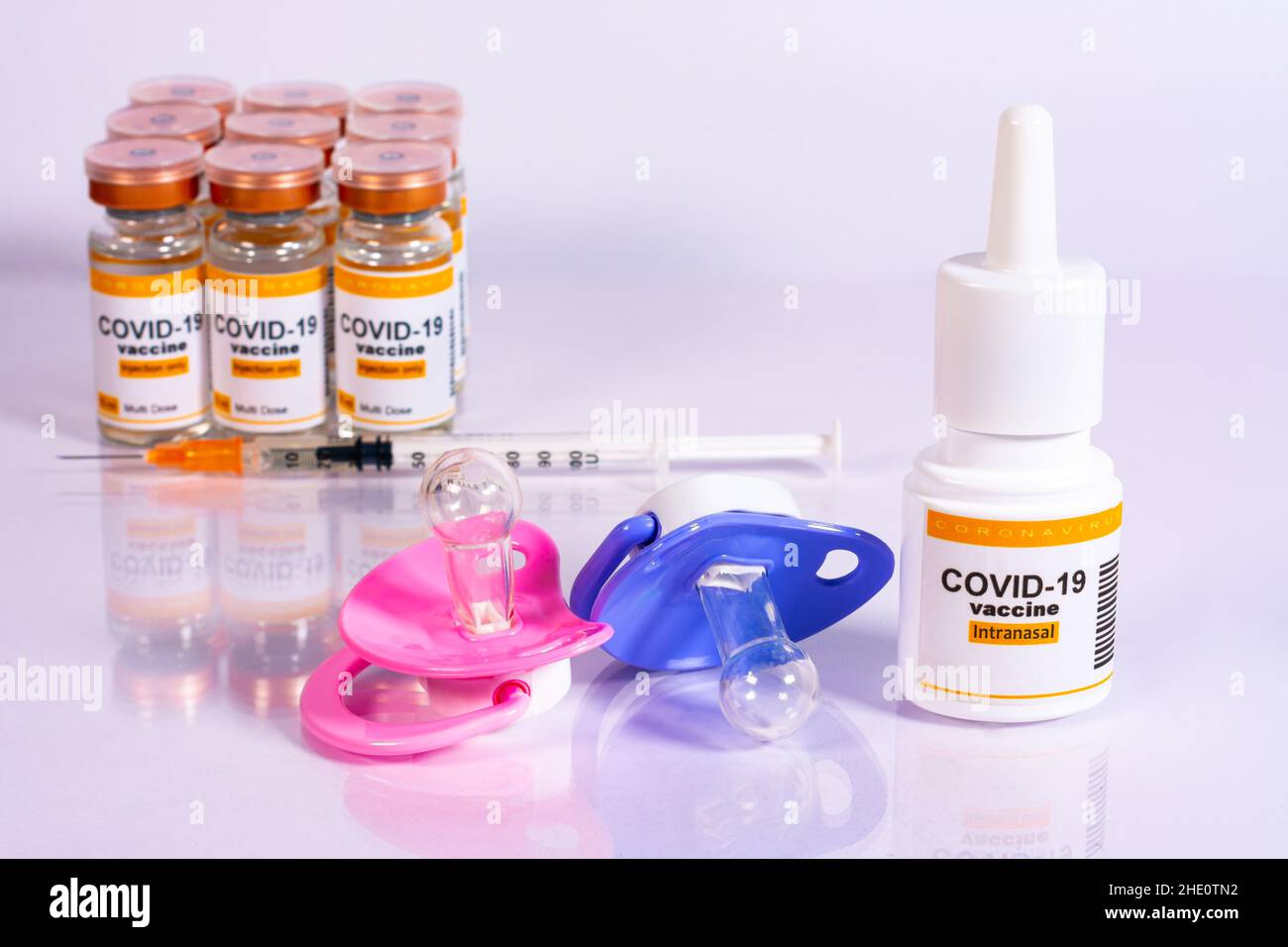 Sucettes pour bébés à côté des flacons, de la seringue et de l'inhalateur avec le vaccin coronavirus.Concept de vaccination des enfants, avec aiguille ou voie nasale ou inhalation Banque D'Images