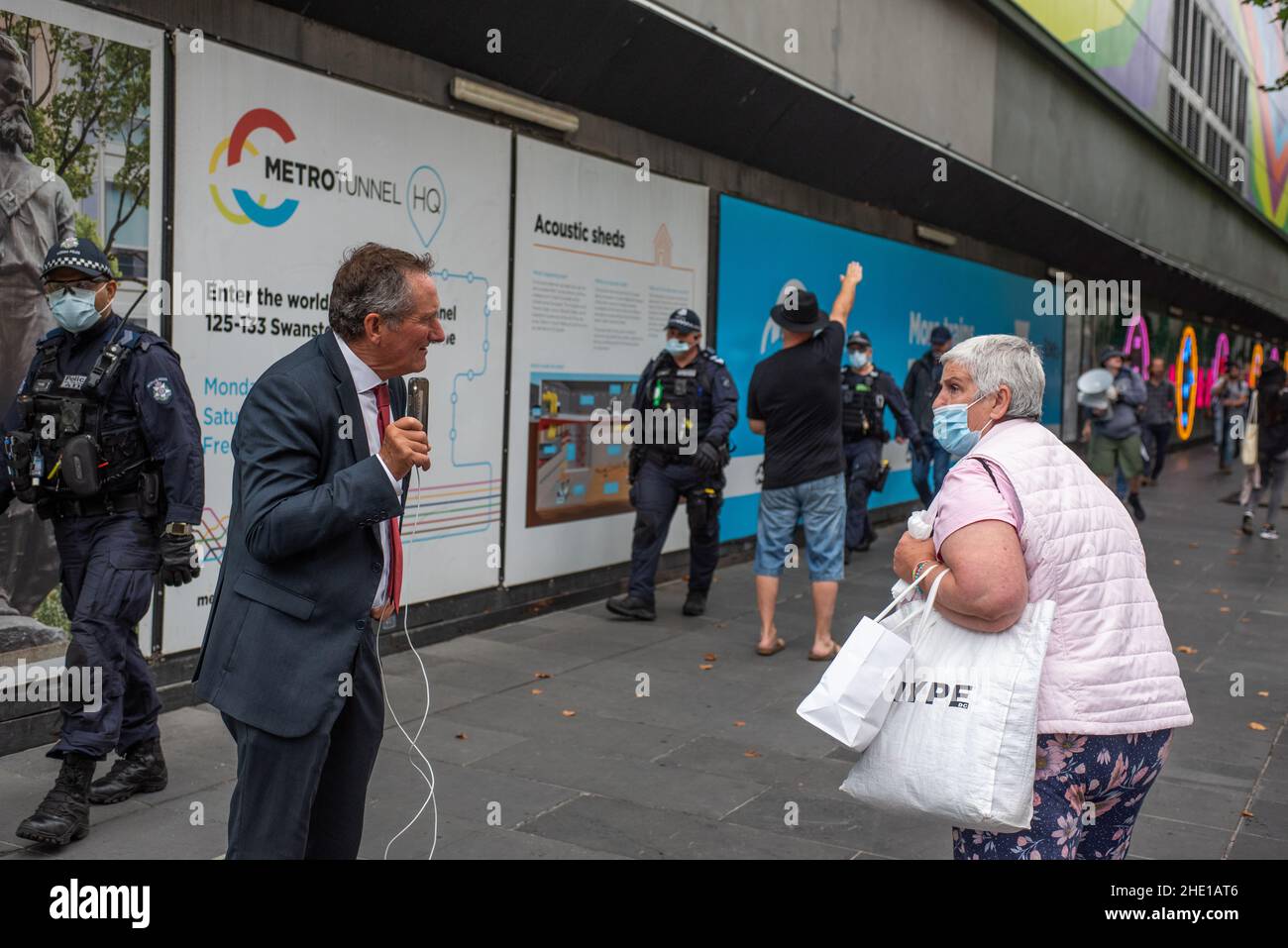 Melbourne, Australie.8th janvier 2022, Melbourne, Australie.Un manifestant anti-vax scanne une femme âgée lors d'une manifestation, tandis qu'en arrière-plan un homme rend un hommage nazi à la marche des officiers de police.Credit: Jay Kogler/Alay Live News Banque D'Images