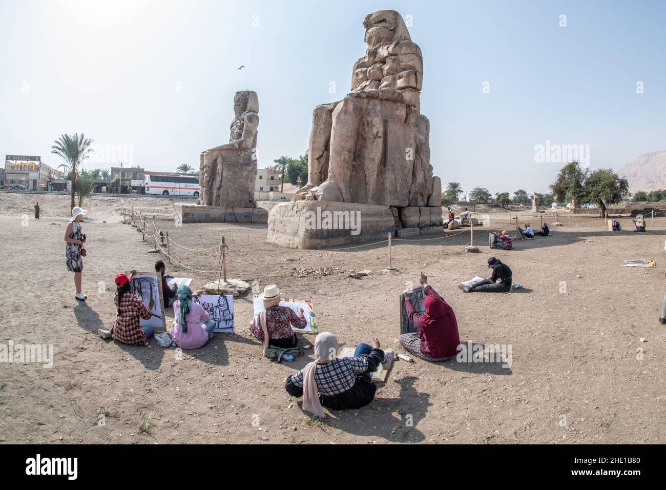 Sur le site historique Colossi of Memnon, un groupe d'étudiants d'art égyptiens s'assoient et dessinent les anciennes statues dans leurs blocs de croquis. Banque D'Images