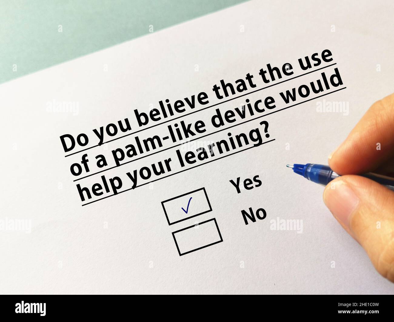 Une personne répond à une question sur l'apprentissage en ligne.La personne croit que l'utilisation d'un appareil de type paume l'aiderait à apprendre. Banque D'Images