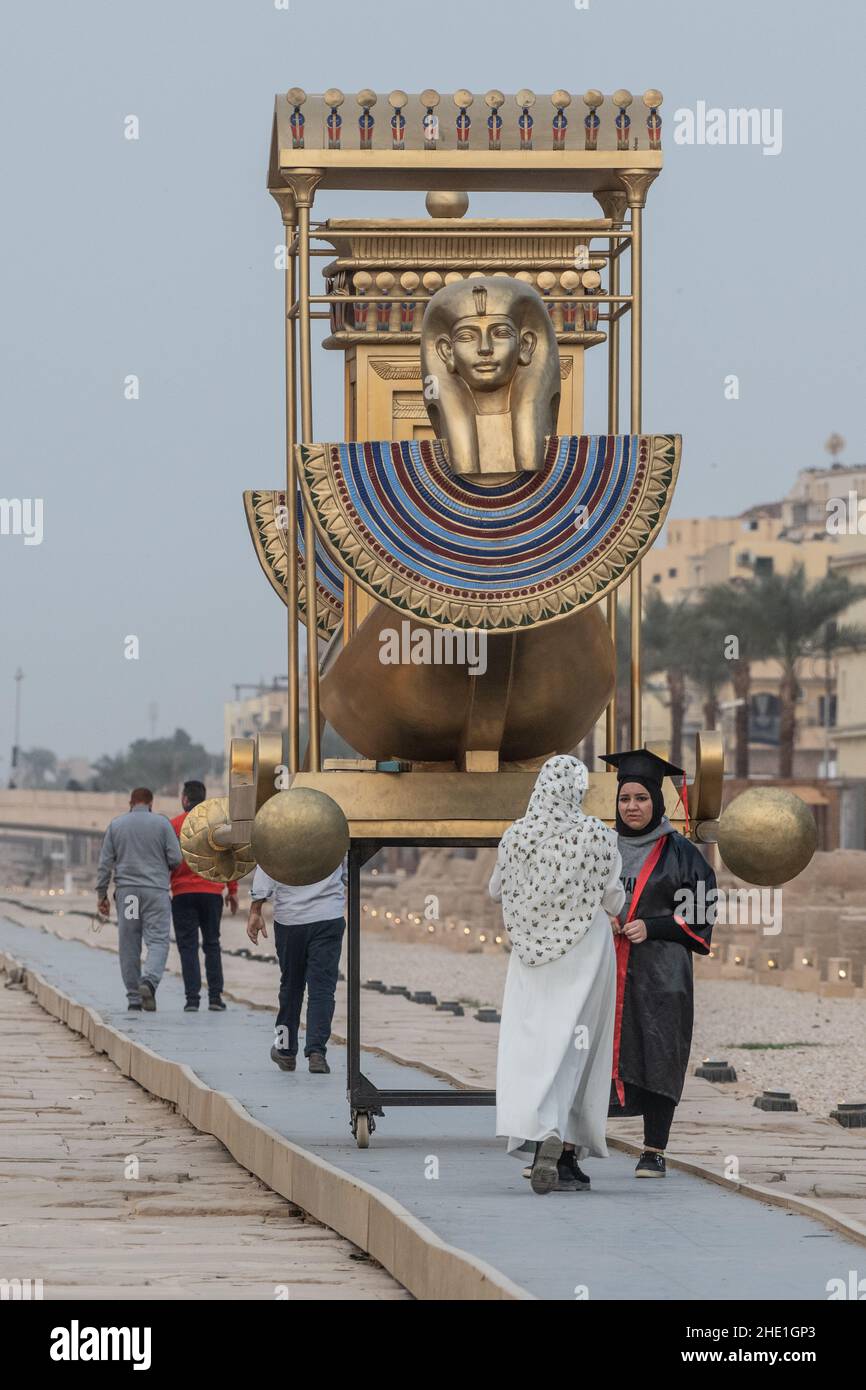 Une réplique de bateau à la décoration ornatelée se trouve sur l'avenue des sphinx, une paire de femmes prennent des photos de graduation à côté. Banque D'Images