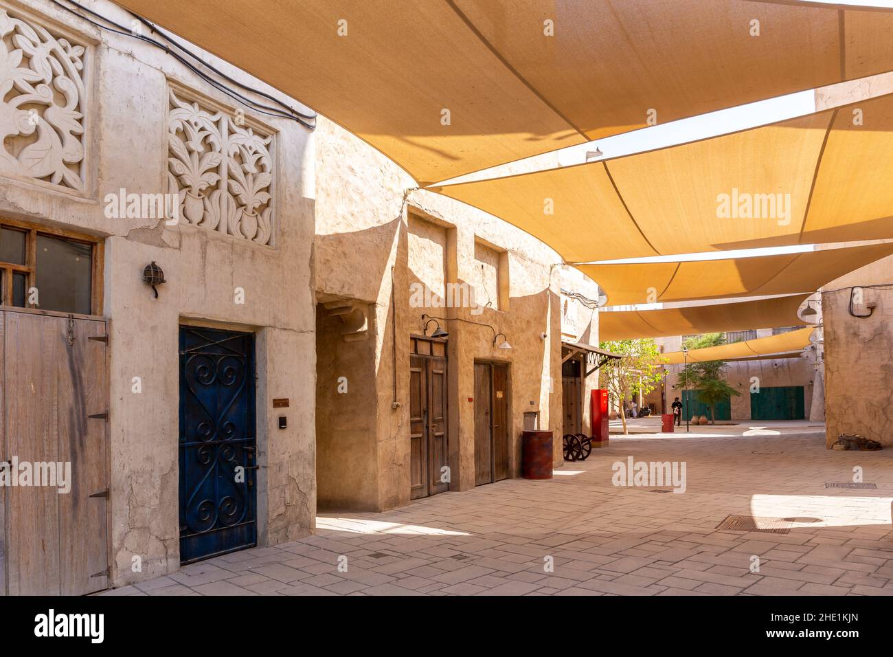 Al Fahidi quartier historique rue en pierre avec des bâtiments traditionnels de style arabe avec ornements et parasols au-dessus, Deira, Dubaï, Émirats Arabes Unis. Banque D'Images