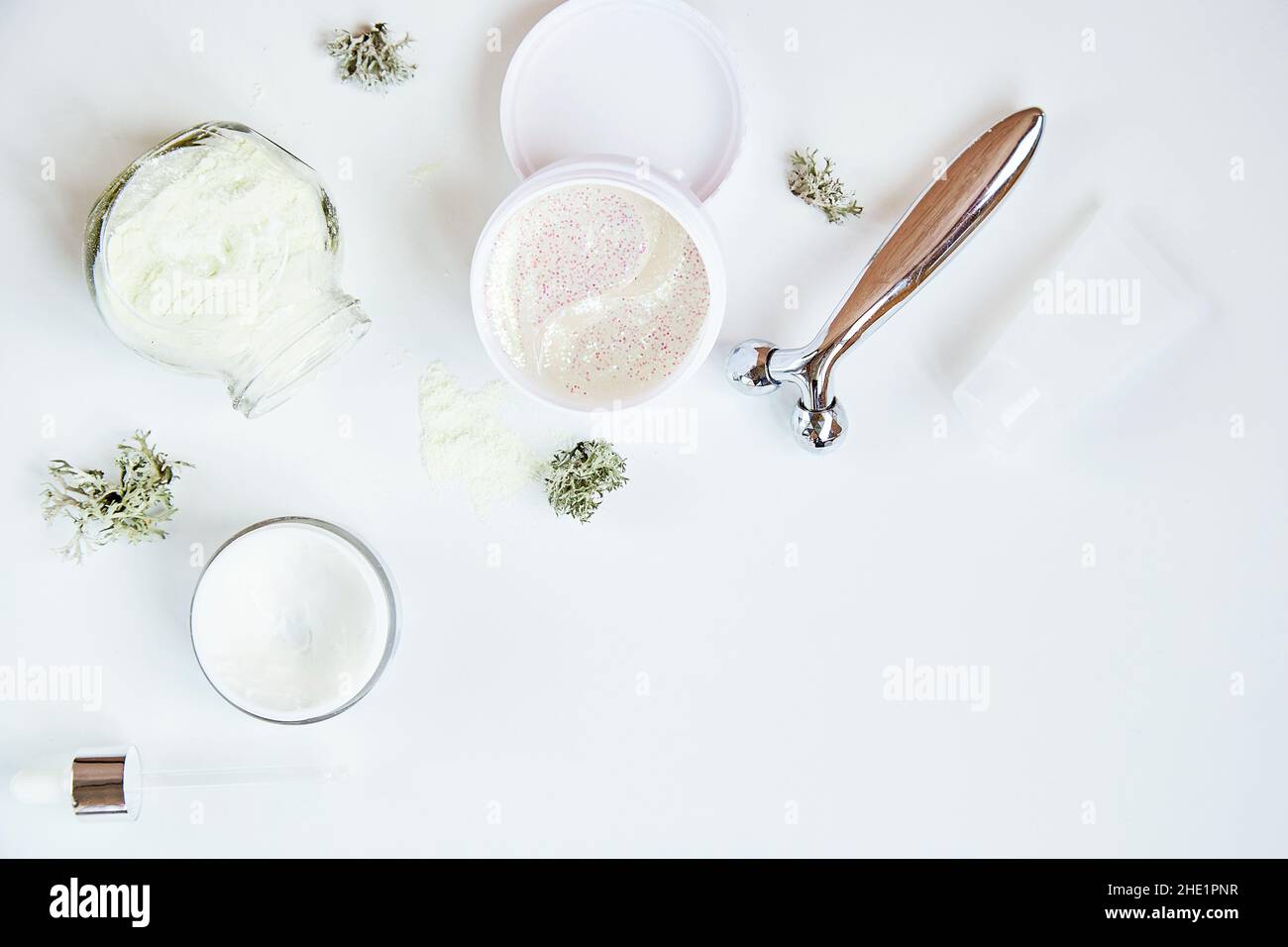 Masque alginate et plaques transparentes.Cosmétiques de soin du visage de bien-être sur fond blanc dégradé.Crème et masseur.Mousse naturelle.Cosmétiques hydratants et hyaluroniques.Produits de dermatologie. Banque D'Images