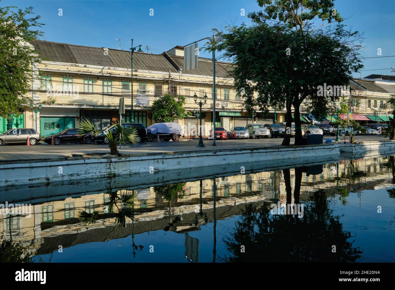 Vieux entrepôts pittoresques et magasins bordant la route d'Atsadang le long de Klong (canal) Lod dans le quartier de la vieille ville de Bangkok, en Thaïlande, se reflète dans l'eau Banque D'Images