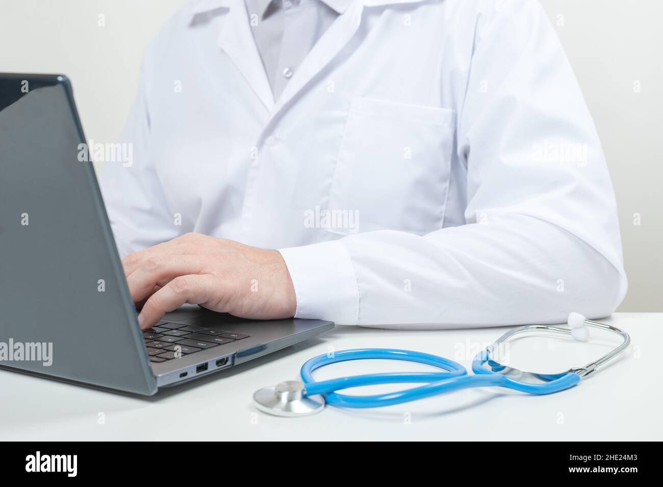 Médecin de sexe masculin au bureau de la clinique.Homme médecin médical professionnel portant un manteau blanc et un stéthoscope travaillant sur un ordinateur sur le lieu de travail.Docteur wor Banque D'Images