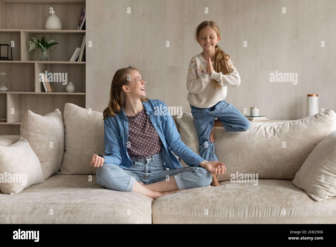 Joyeux deux générations de famille faisant des exercices de yoga à la maison. Banque D'Images