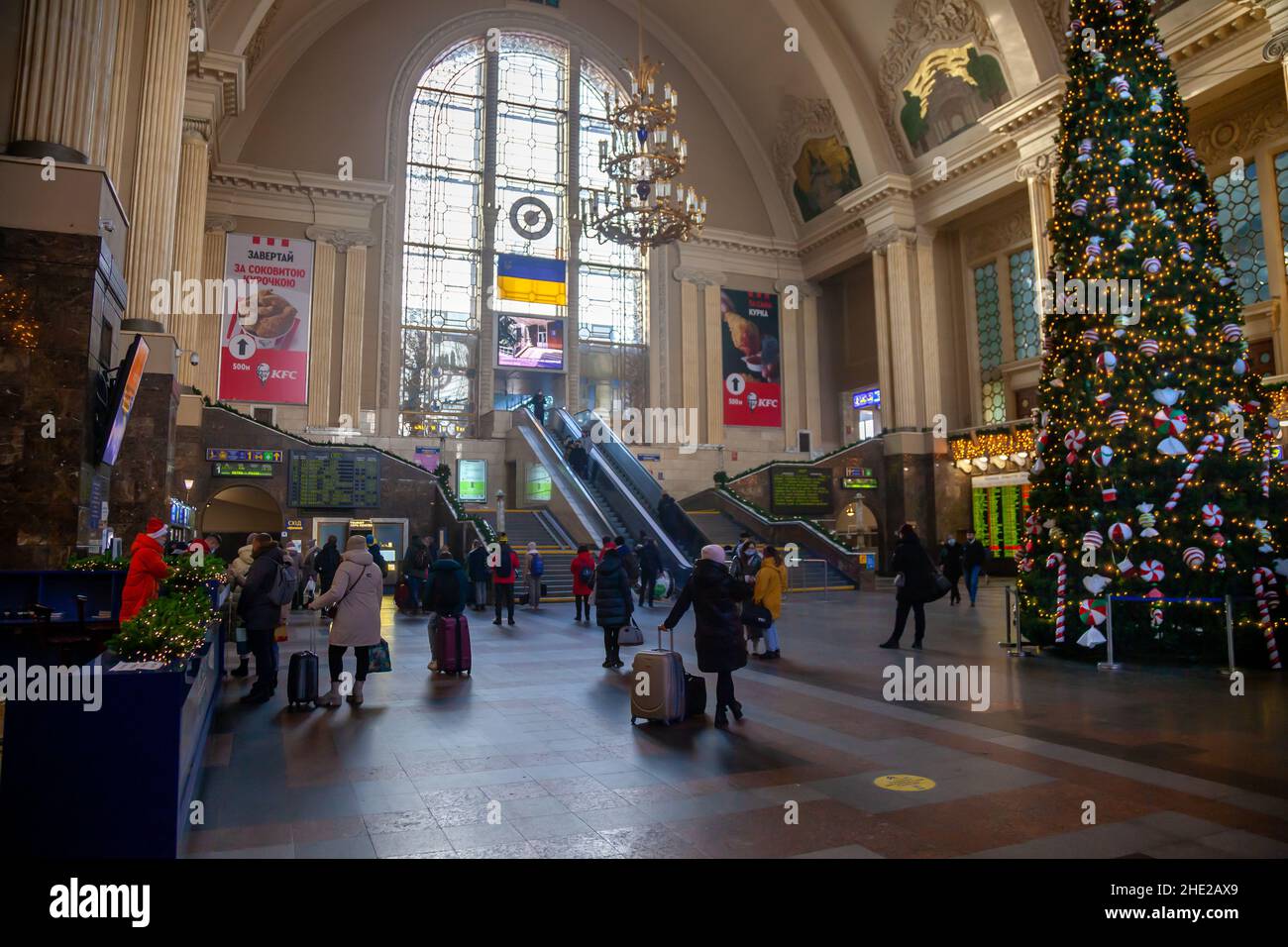 Ukraine, Kiev - 7 janvier 2022 : bâtiment de la gare à l'intérieur.Hall avec un arbre de noël, escalier roulant et personnes avec des valises voyagent et attendent leur train.Voyageurs à la gare Banque D'Images