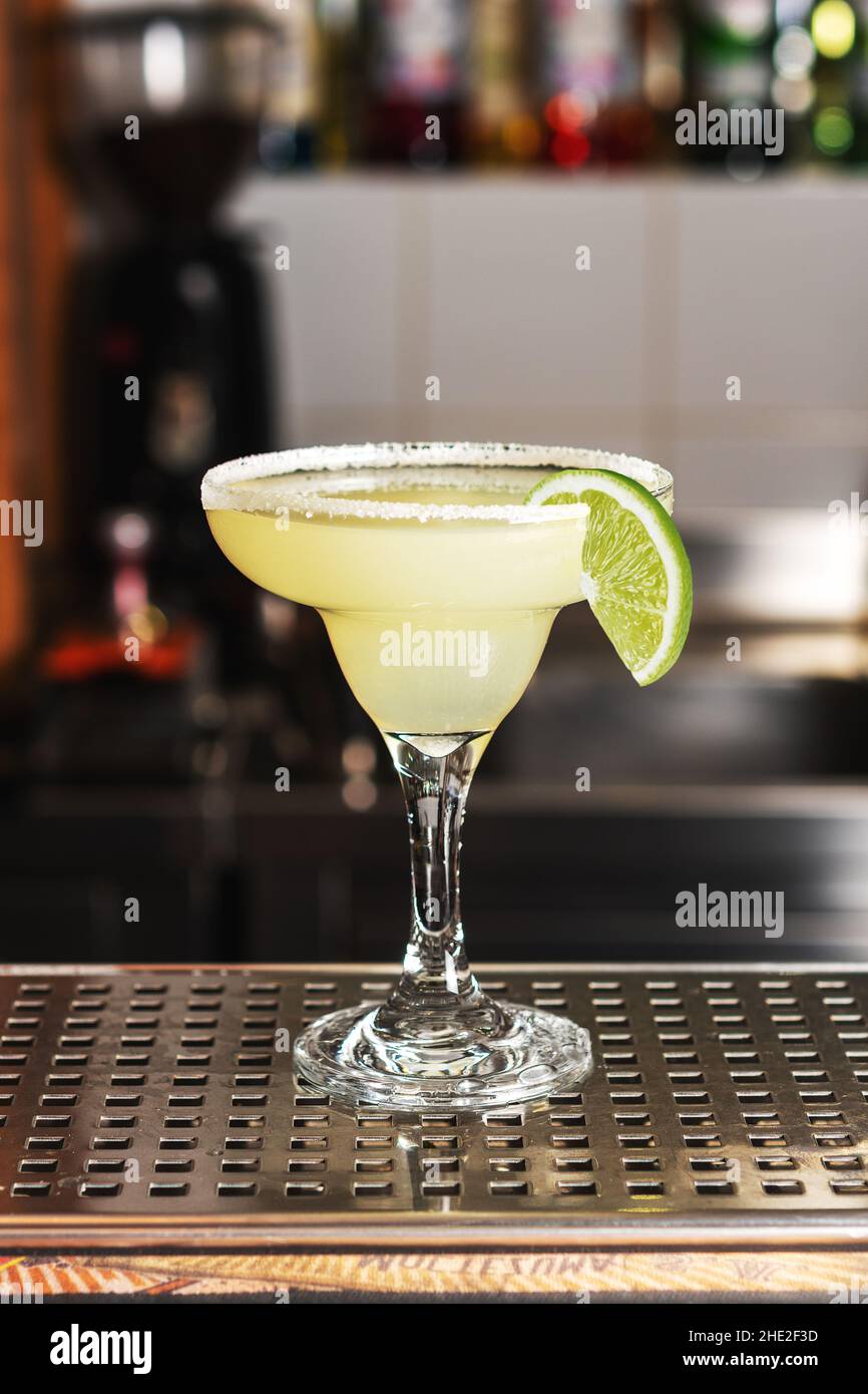 Cocktail de margarita au citron vert classique avec tequila, jus de lime, glace pilée et un peu de sel sur le bord du verre, garni d'une tranche de lime. Banque D'Images