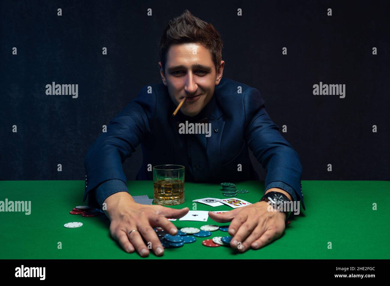 Joyeux joueur de poker gagnant avec des cartes et des jetons de poker. Banque D'Images