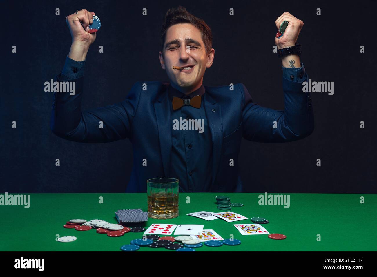 Joyeux joueur de poker gagnant avec des cartes et des jetons de poker. Banque D'Images