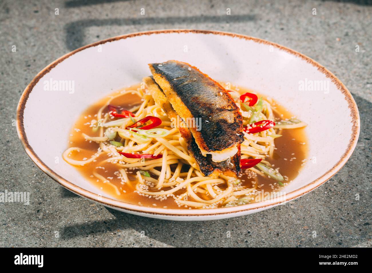 Gros plan d'une soupe de macaron avec du poisson et des légumes servis dans  un bol blanc Photo Stock - Alamy