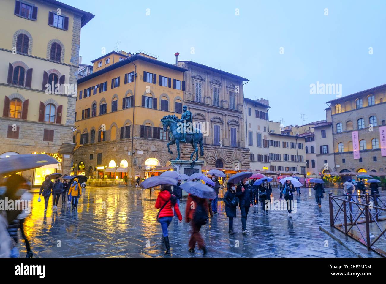 2021 décembre Florence, Italie : le monument équestre de la statue de Cosimo sur la place, piazza della Signoria.Touristes marchant avec des parasols dans le Banque D'Images