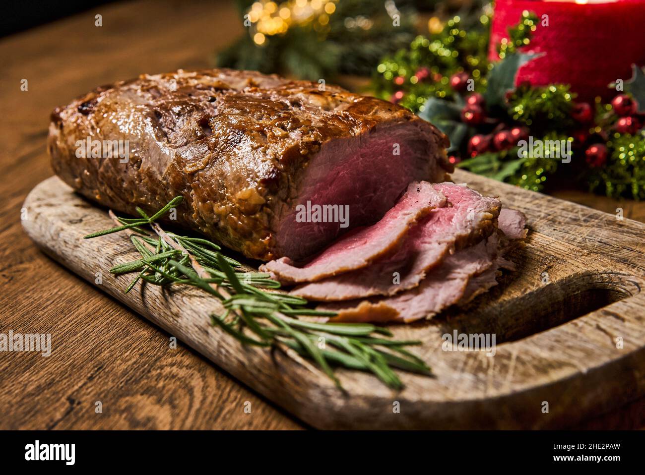 Viande rôtie en tranches, isolée sur fond de bois. Banque D'Images