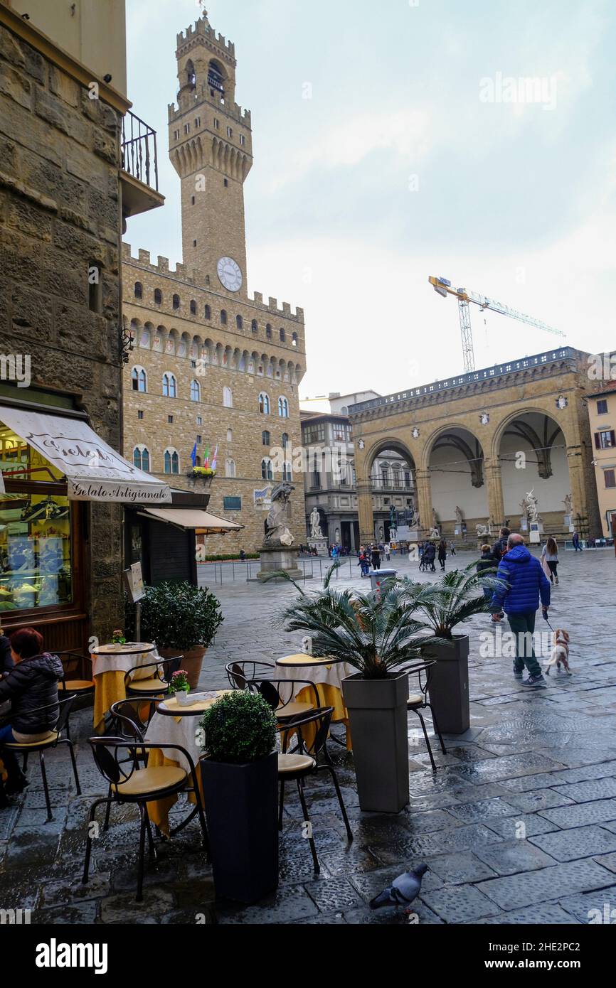 2021 décembre Florence, Italie: Café avec des gens sur la place, piazza della Signoria de l'autre côté de la tour du palais Vecchio Banque D'Images