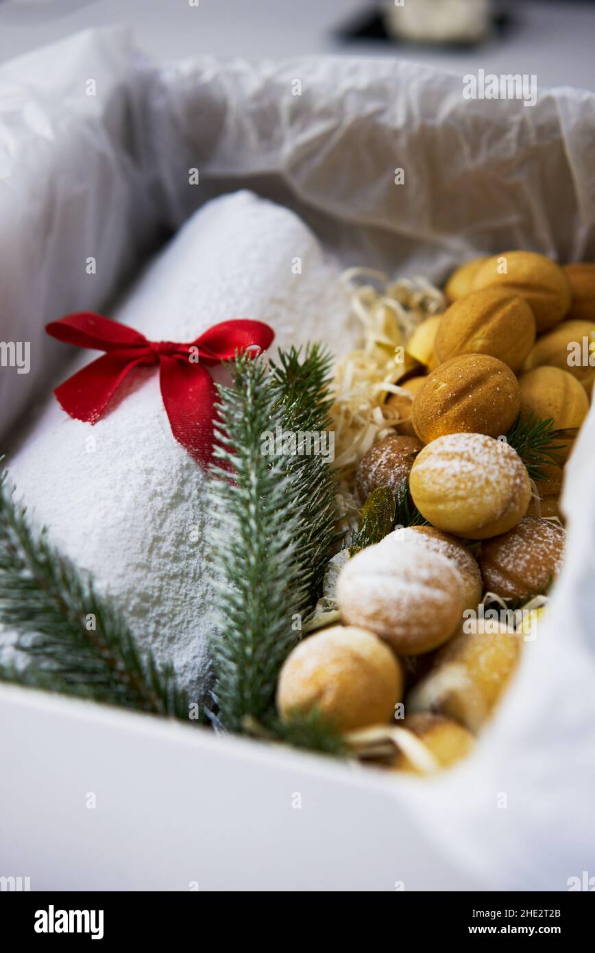 Un stollen de Noël traditionnel fait de fruits secs et de noix arrosées de sucre en poudre sur le fond d'un décor de Noël avec des bougies Banque D'Images