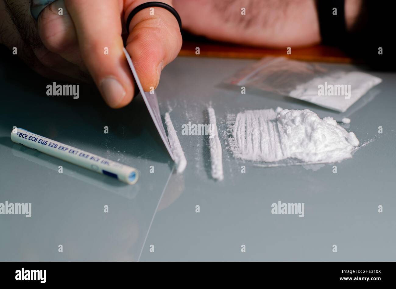 L'homme fractionne la cocaïne en bandes et puis en ronflements.Concept de narcotiques. Banque D'Images