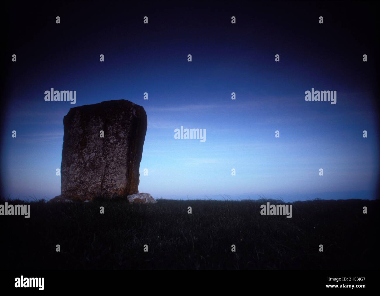 Vue sur une Rune Stone sur la rive, au bord de la mer.Analogique.Printemps et prairies verdoyantes, le soir. Banque D'Images