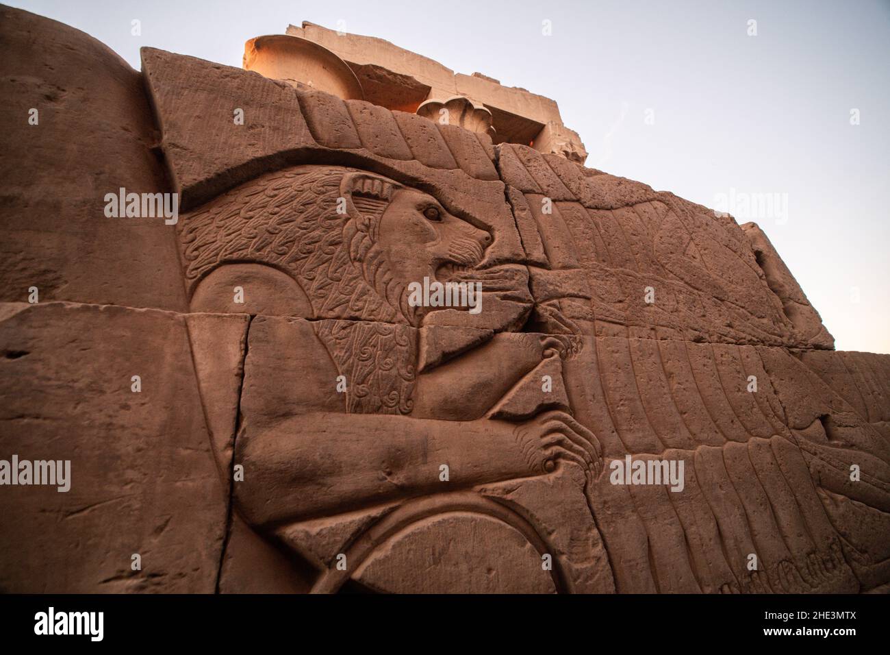 Une sculpture ancienne dans les ruines du temple de Kom Ombo en Égypte dépeint un lion piquant une main. Banque D'Images