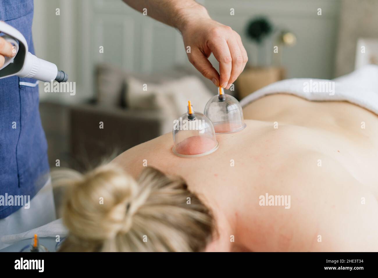 Une femme fait un massage de la hanche avec un pot à vide pour un massage anti-cellulite. Banque D'Images