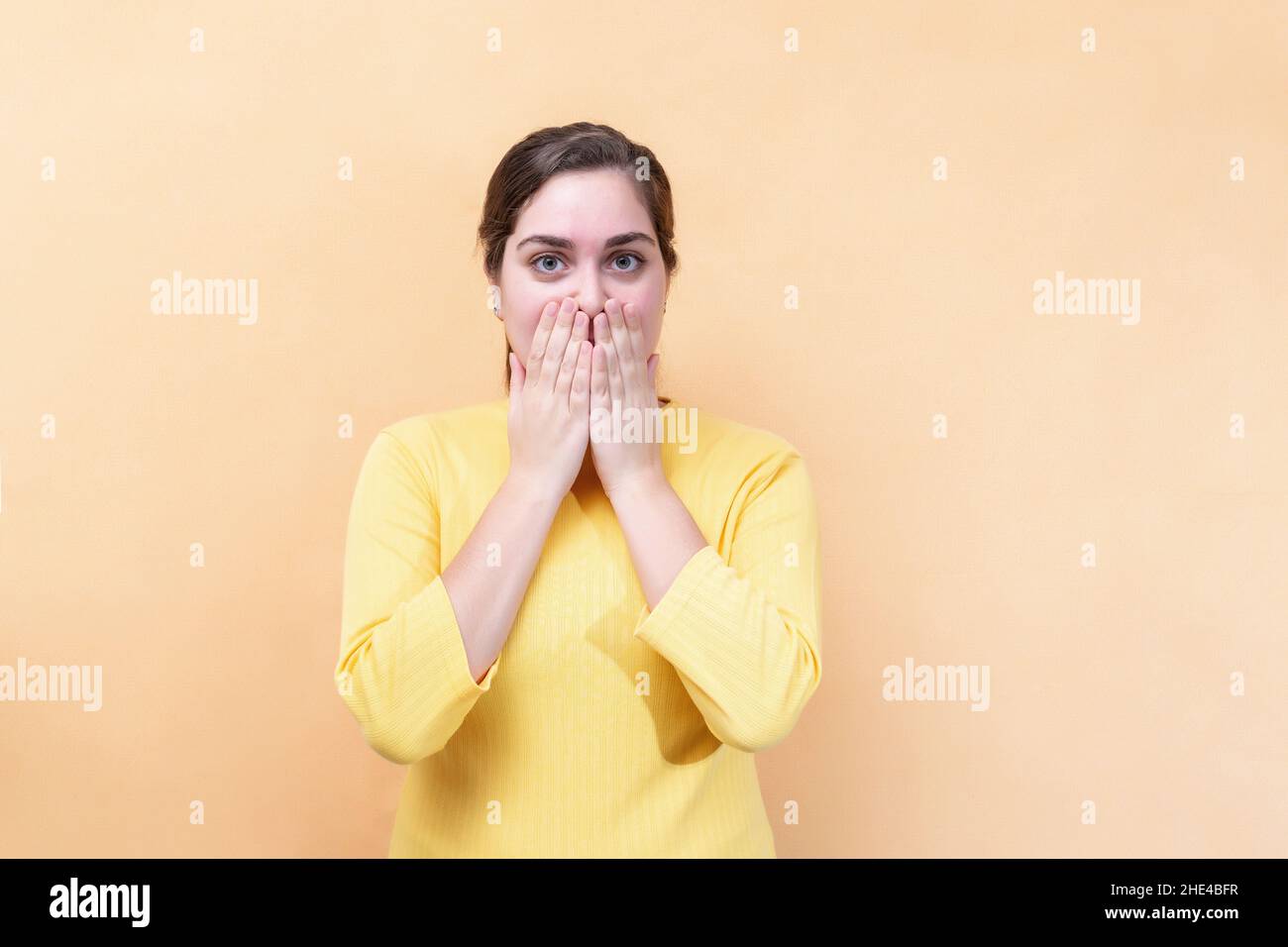 Je ne peux rien dire.Surprise, Oups !La fille ferme la bouche avec les paumes. Banque D'Images