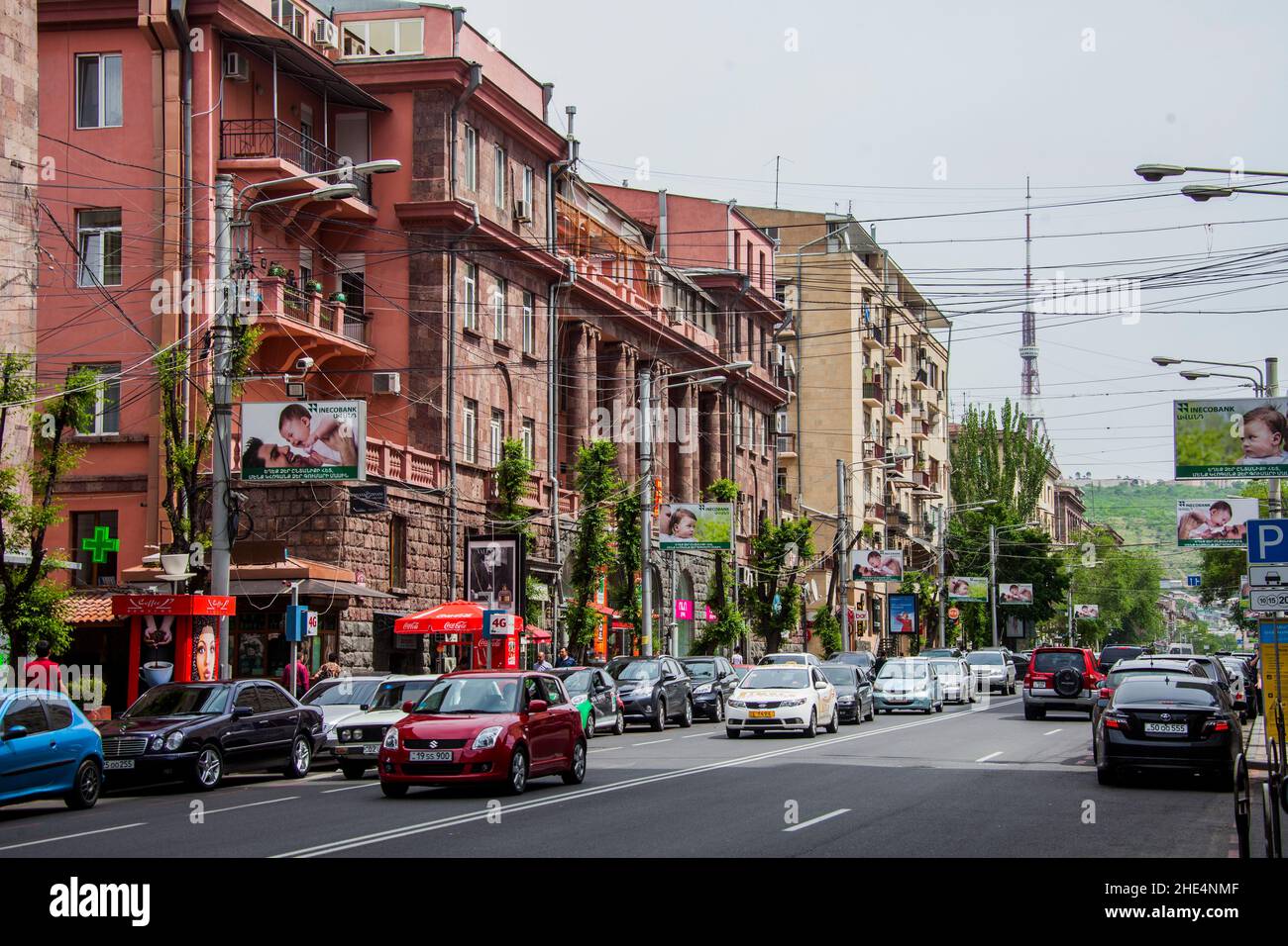 Vue sur les bâtiments, la rue et les voitures contre un ciel nuageux à Erevan, Arménie. Banque D'Images