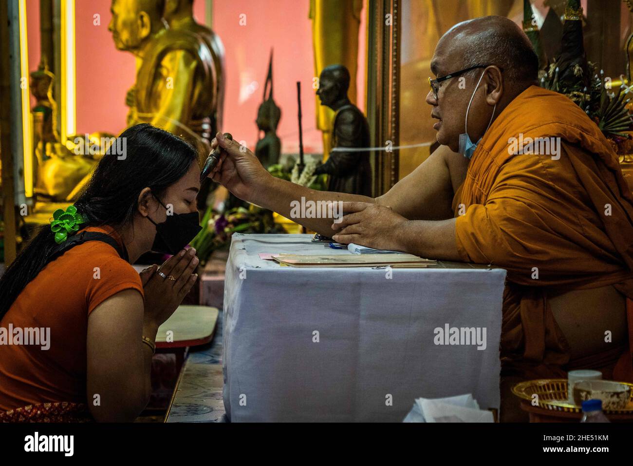 Bangkok, Thaïlande.1st janvier 2022.Un moine prie avec un dévot thaïlandais avant de prendre part au rituel de résurrection au temple.les dévotés sont ressuscités dans un rituel annuel du nouvel an à Wat Takien près de Nonthaburi.Ce rite commence par une prière suivie par les participants qui chantent avec des fils saints enveloppés autour de leur tête avant de s'allonger dans un cercueil à « mort » et d'être nettoyés.(Image de crédit : © Matt Hunt/SOPA Images via ZUMA Press Wire) Banque D'Images