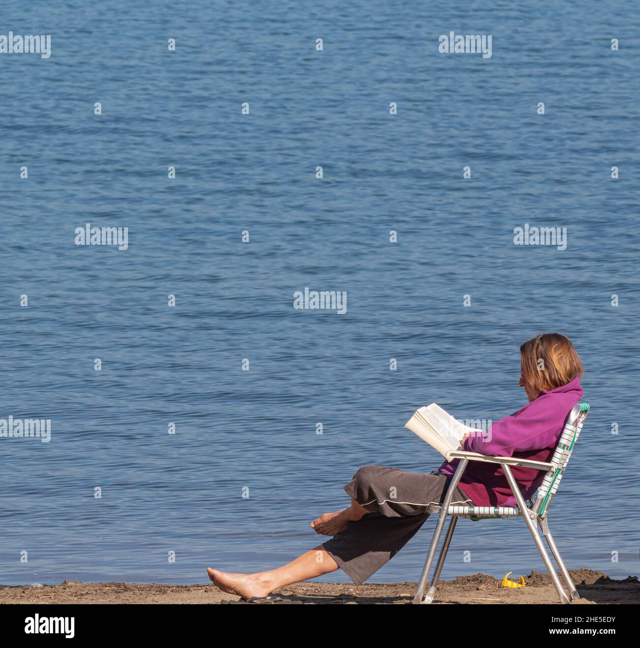 Moments de détente, femme âgée lisant un livre au bord d'un lac.Vacances d'été dans la nature, assis au lac avec livre.Photo de voyage, mise au point sélective, Copy spa Banque D'Images